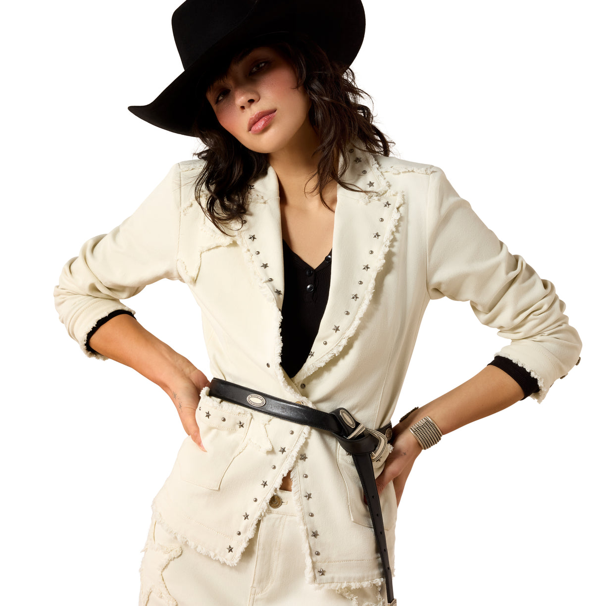 Woman wearing a white jacket with black trim, black hat, and black belt on a white background