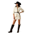 Woman in a white dress, black cowboy hat, and black boots on a white background