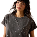 Woman wearing a dark gray t-shirt with star patterns on a white background