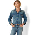 Woman wearing a denim shirt and jeans on a white background