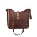 Brown leather handbag with white stitching on a white background