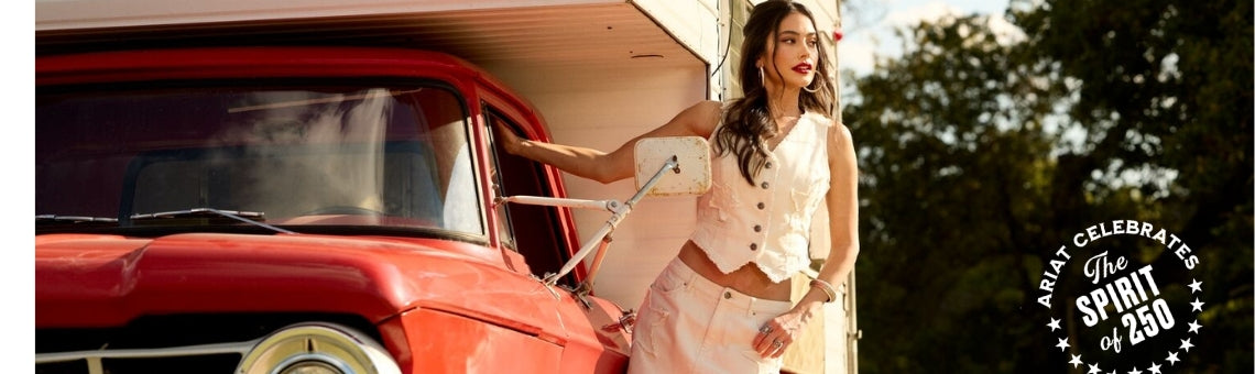 Woman wearing Americana Collection Ariat Clothing standing next to a red truck