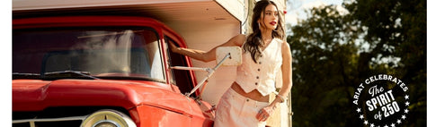 Woman wearing Americana Collection Ariat Clothing standing next to a red truck