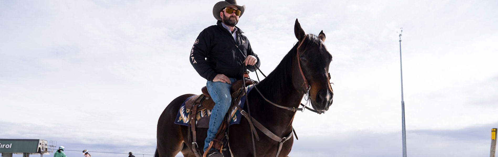 Cowboy riding a horse in the snow wearing Ariat Acclimatize denim jeans