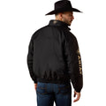 Man wearing a black jacket with 'Ariat' branding on the back, standing against a white background.
