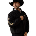 Man wearing a black jacket with gold text and logos on a white background