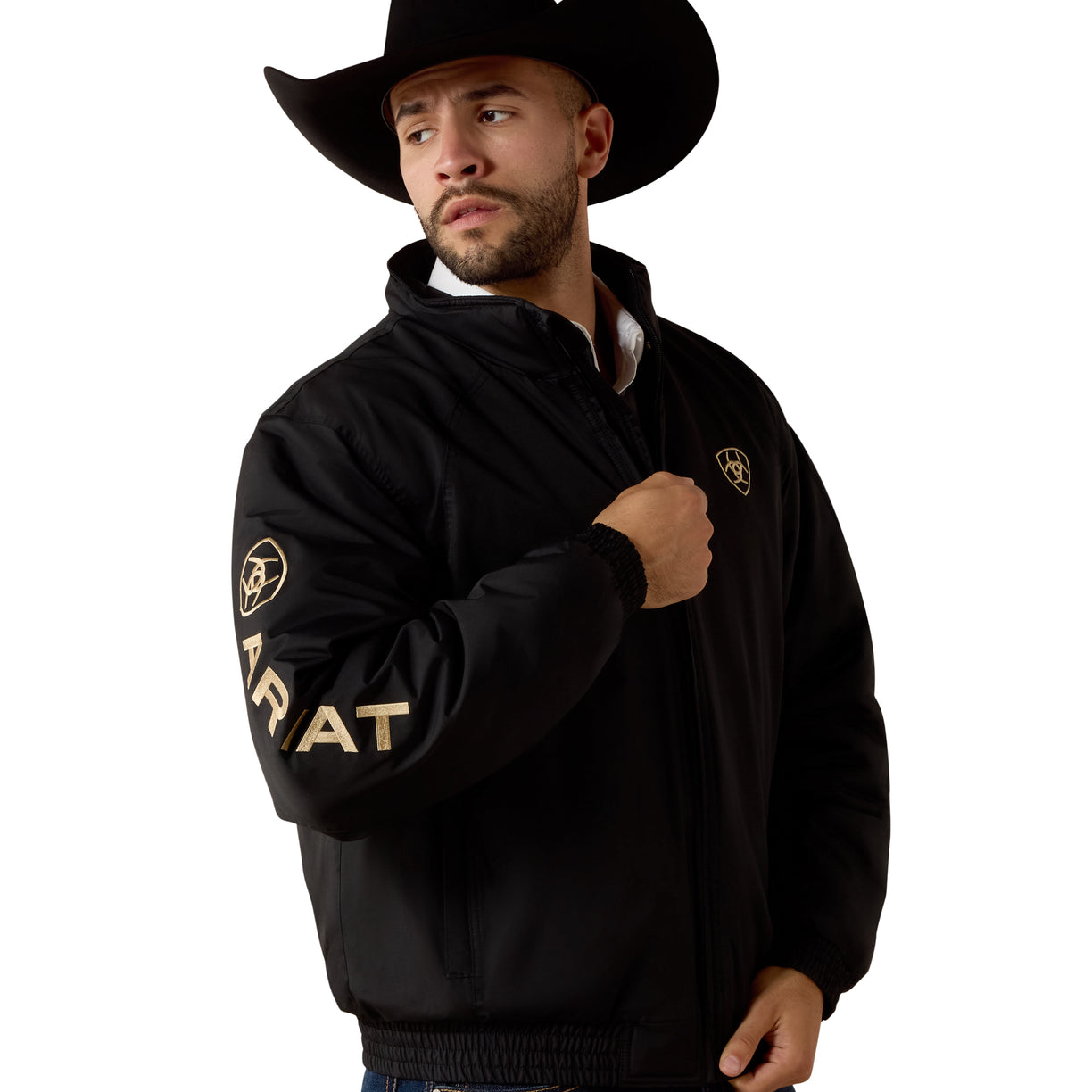 Man wearing a black jacket with gold text and logos on a white background