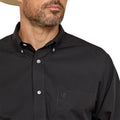 Close-up of a black button-up shirt with a brand logo on a white background