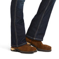 Brown suede shoes worn with dark blue jeans on a white background