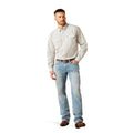 Man wearing a patterned shirt and light blue jeans on a white background