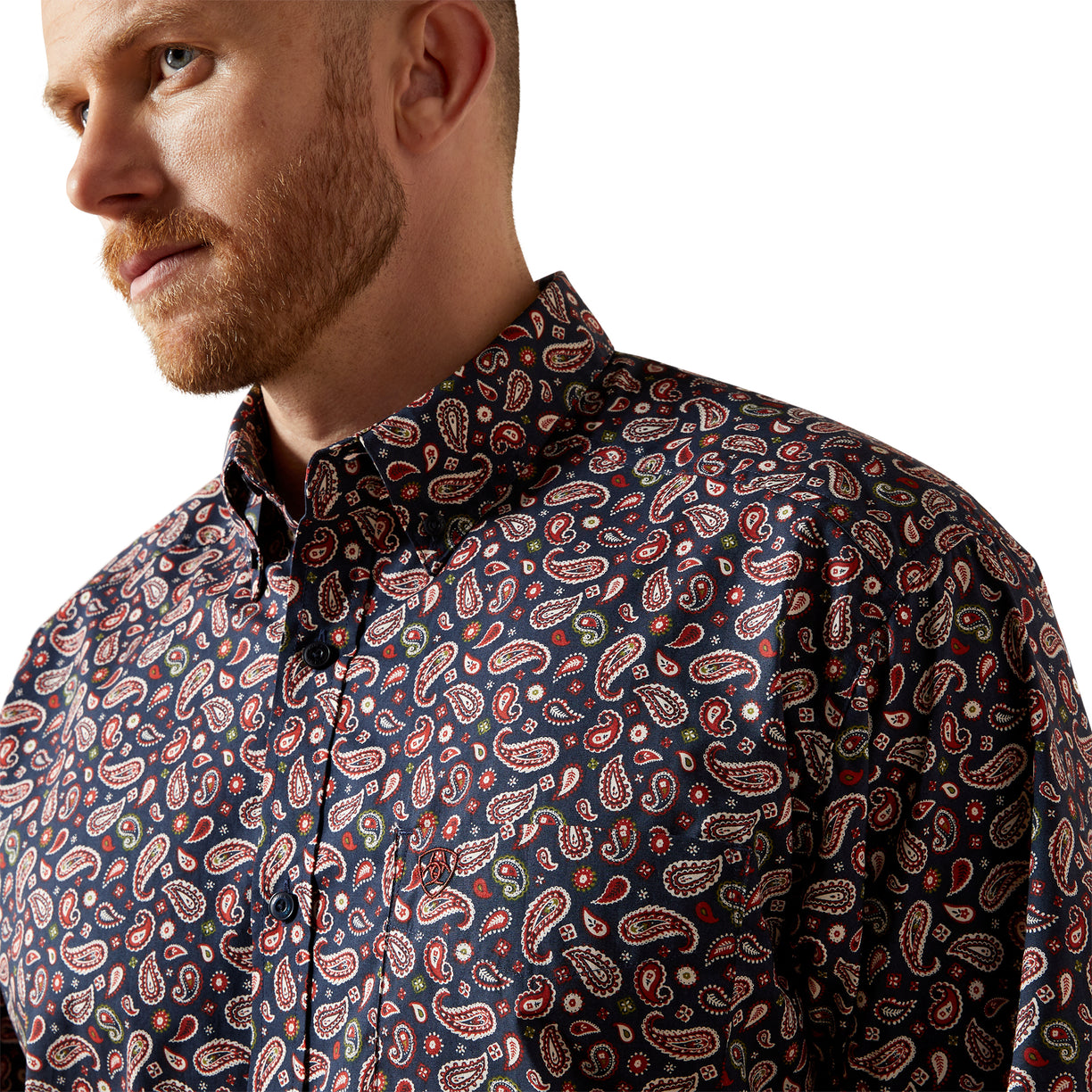 Man wearing a patterned shirt with a neutral background