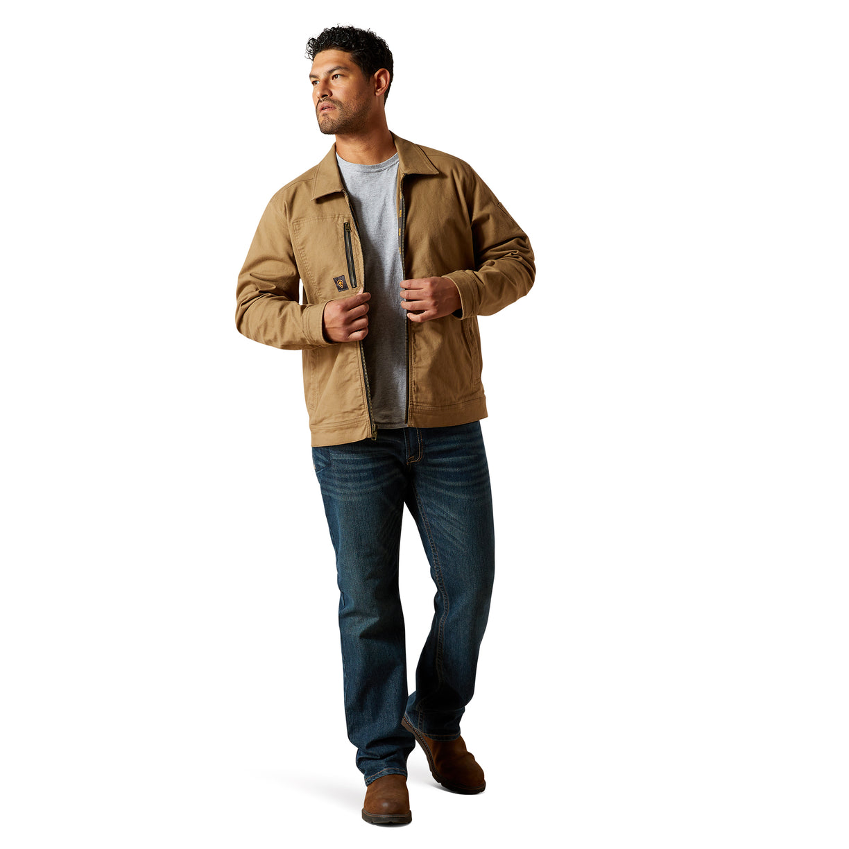Man wearing a tan jacket and blue jeans on a white background
