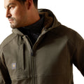 Man wearing a brown jacket with a visible brand logo on a white background