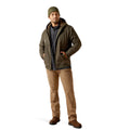 Man wearing a green jacket, beanie, and brown pants on a white background