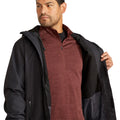 Man wearing a black jacket over a maroon shirt on a white background