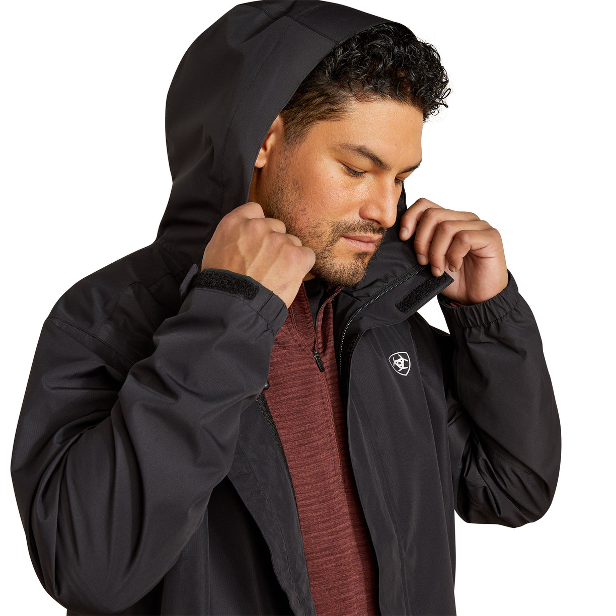 Man wearing a black jacket with a brand logo on a white background