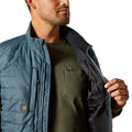 Person wearing a blue puffer vest over a green shirt with Ariat logo.
