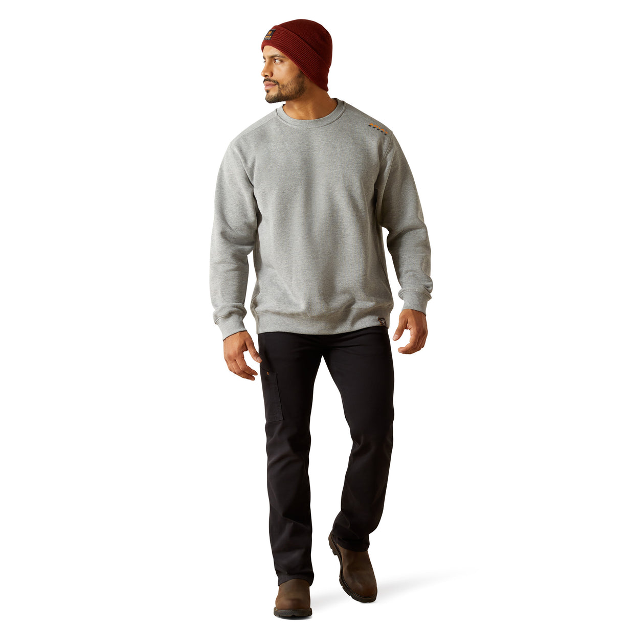 Man wearing a gray sweatshirt, black pants, and a red beanie on a white background