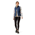 Woman wearing a blue puffer vest over a floral shirt on a white background
