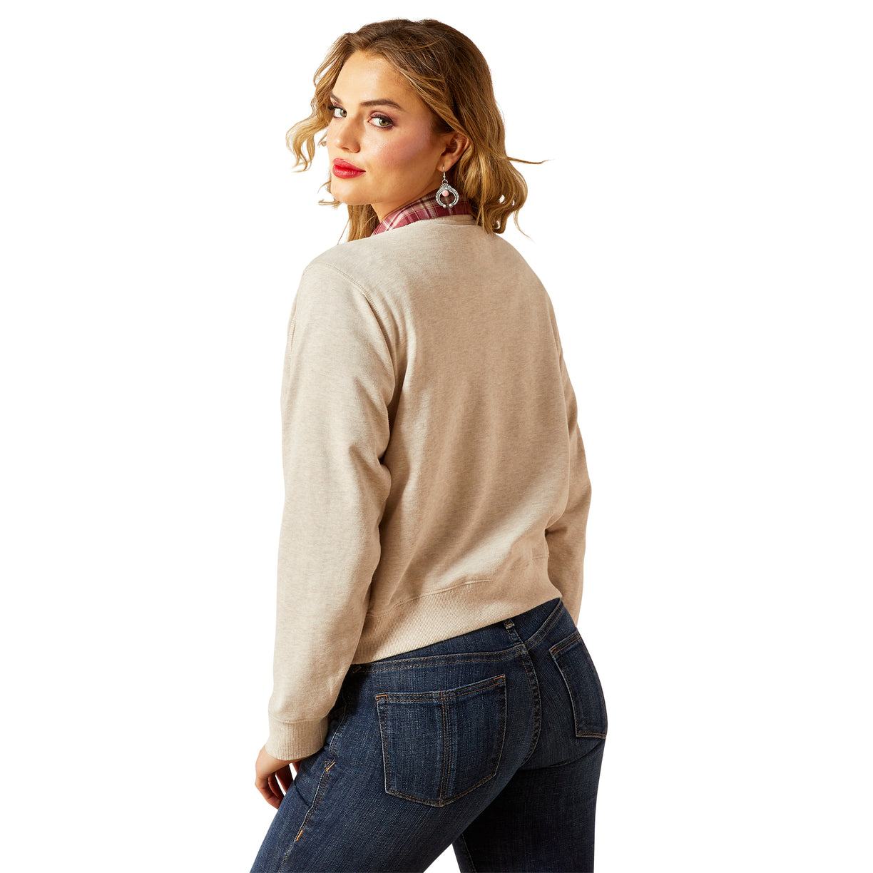 Woman wearing a beige sweater and blue jeans on a white background