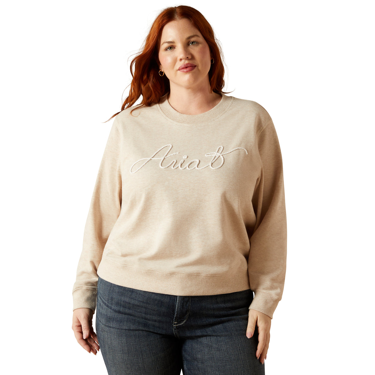 Woman wearing a beige sweatshirt with 'Ania's' embroidery on a white background