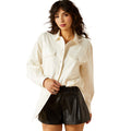 Woman wearing a white shirt and black leather shorts on a white background