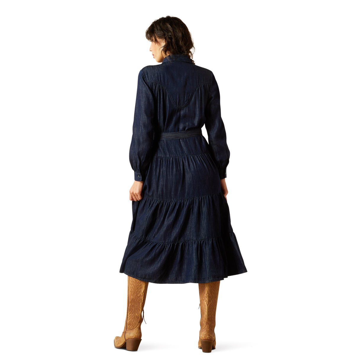 Woman wearing a navy blue dress with long sleeves and a belt, standing on a white background.