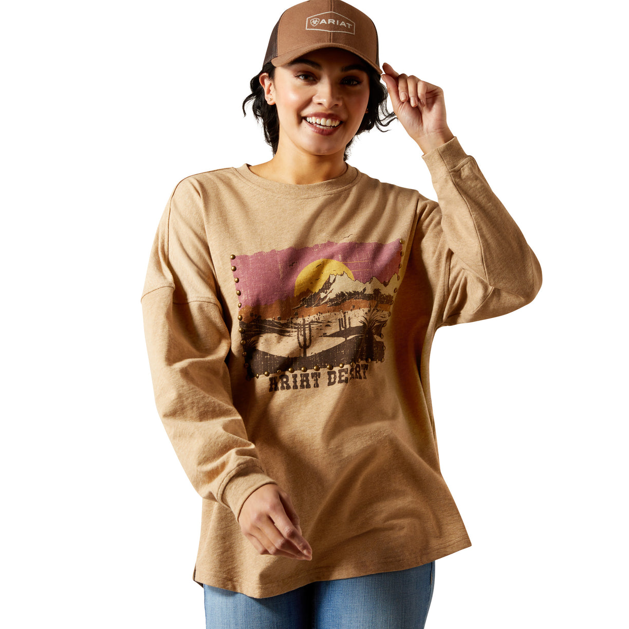 Person wearing a beige long-sleeve shirt with a graphic design and a cap on a white background