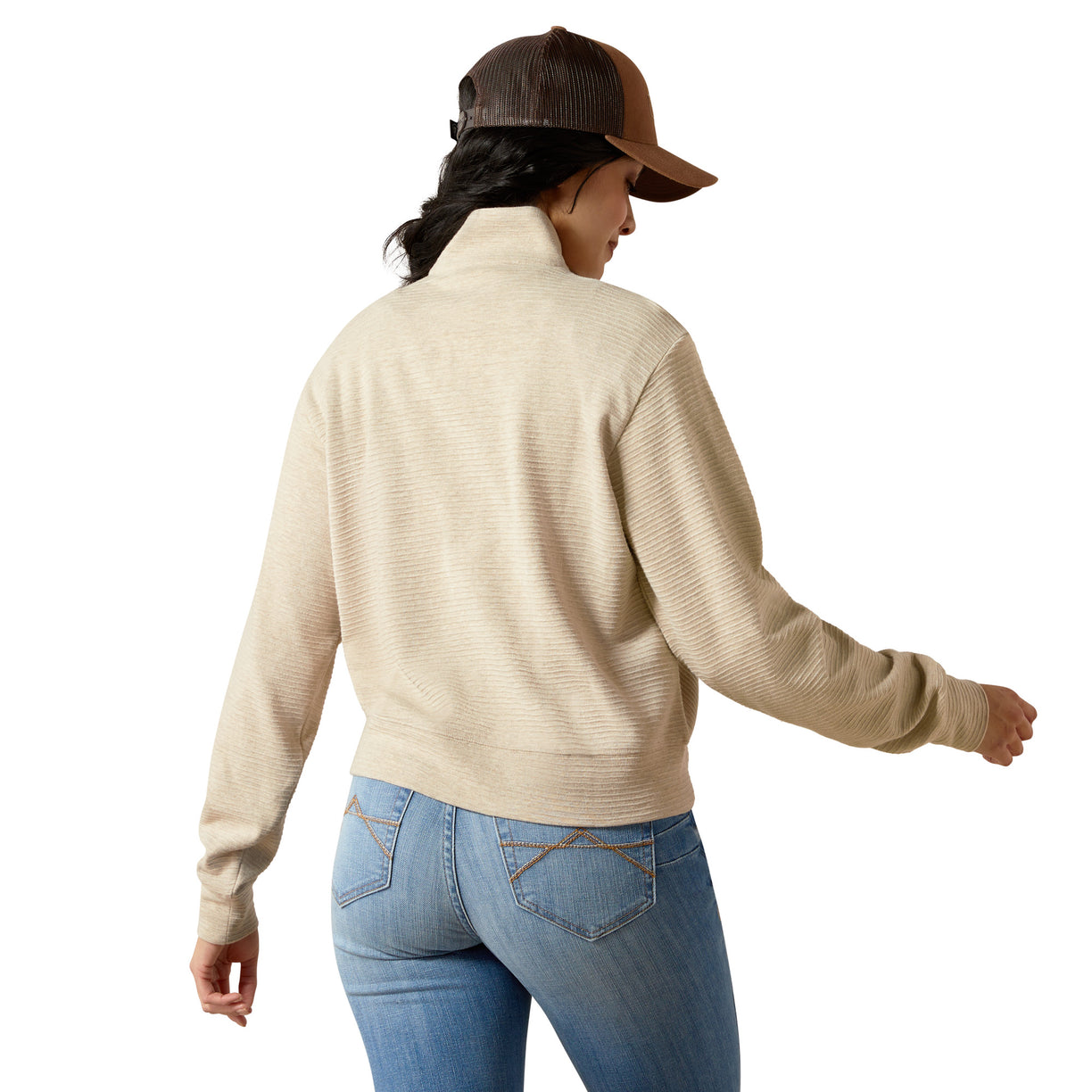 Person wearing a beige sweater and blue jeans on a white background