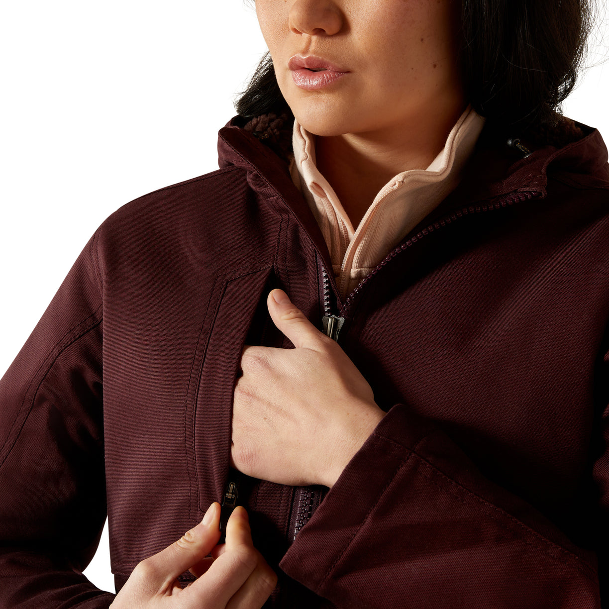 Person wearing a dark brown jacket with a white shirt underneath on a white background