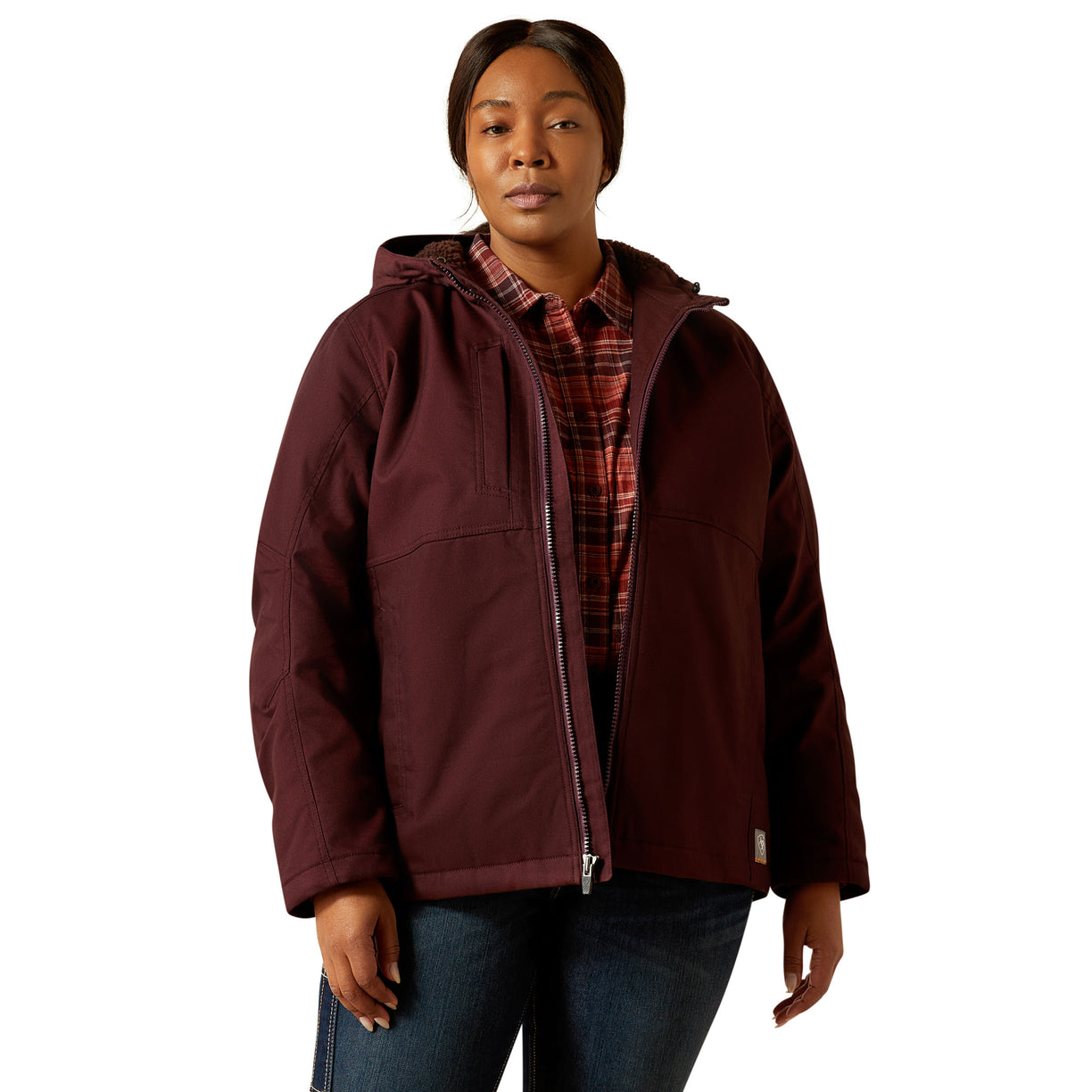 Person wearing a maroon jacket over a plaid shirt on a white background