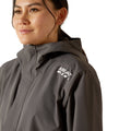 Person wearing a gray raincoat with Ariat logo on a white background