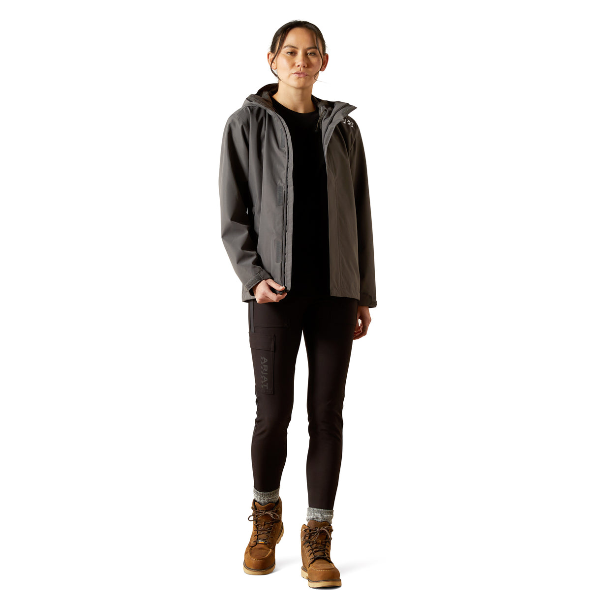 Person wearing a gray jacket with a hood, black pants, and brown boots on a white background