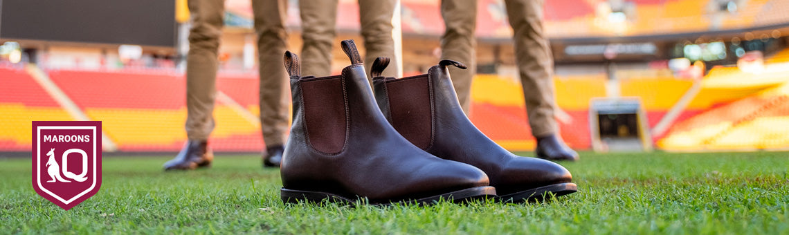 Queensland Maroons players at Suncorp Stadium in background with Ariat Stanbroke brown boots in the foreground.