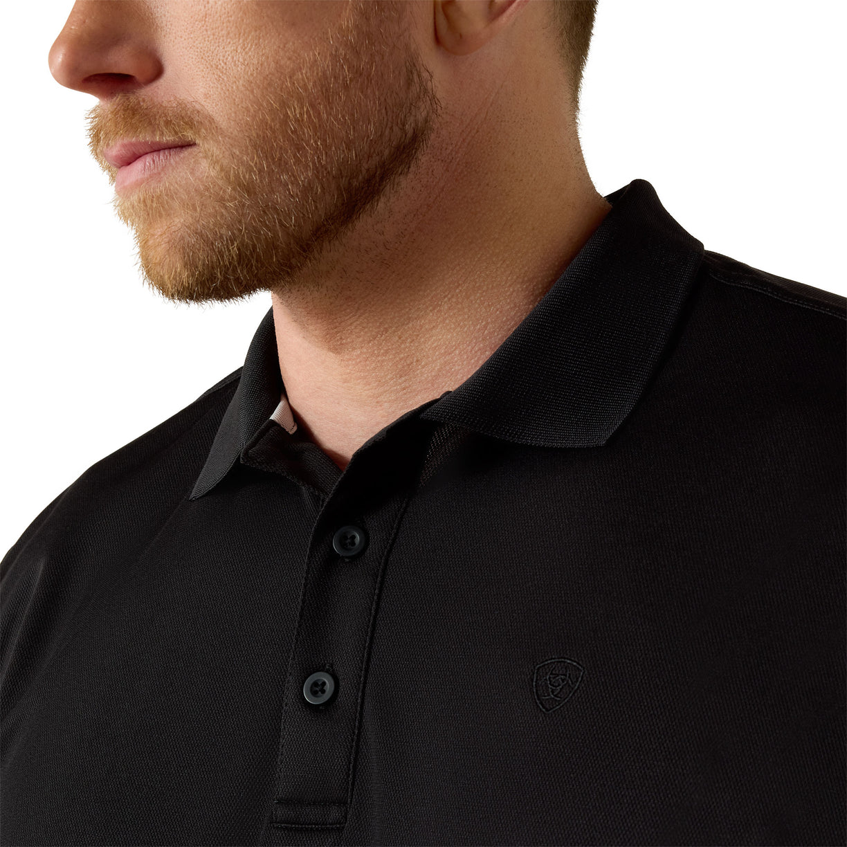 Close-up of a person wearing a black polo shirt with a brand logo on a white background