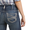 Close-up of blue jeans with a decorative pocket on a white background