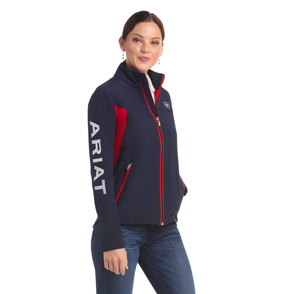 Woman wearing a navy jacket with red accents and 'Ariat' branding on a white background