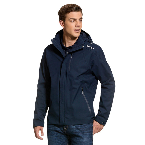 Man wearing a navy jacket and jeans on a light gray background