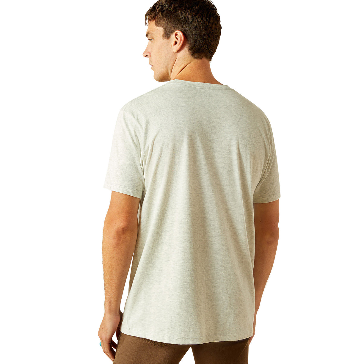 Man wearing a light gray t-shirt with Ariat logo on a white background