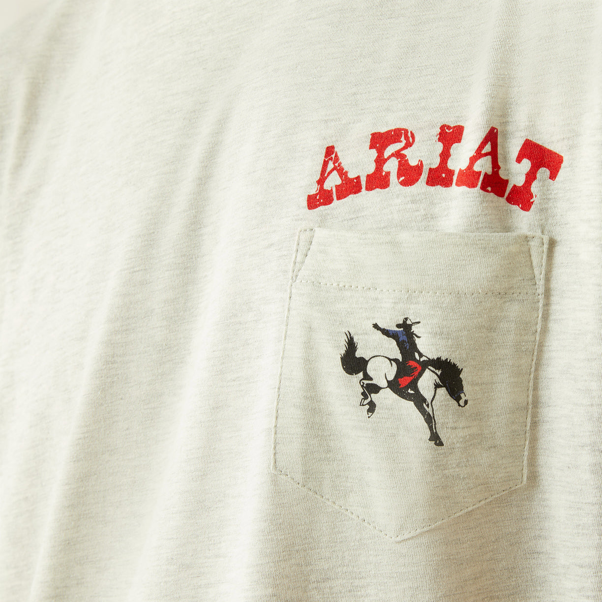 Man wearing a light gray t-shirt with Ariat logo on a white background