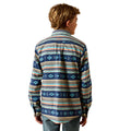 A boy viewed from the back wearing a long-sleeve button-up shirt with a colorful geometric tribal pattern in navy, blue, orange, and beige, paired with blue jeans against a white background.