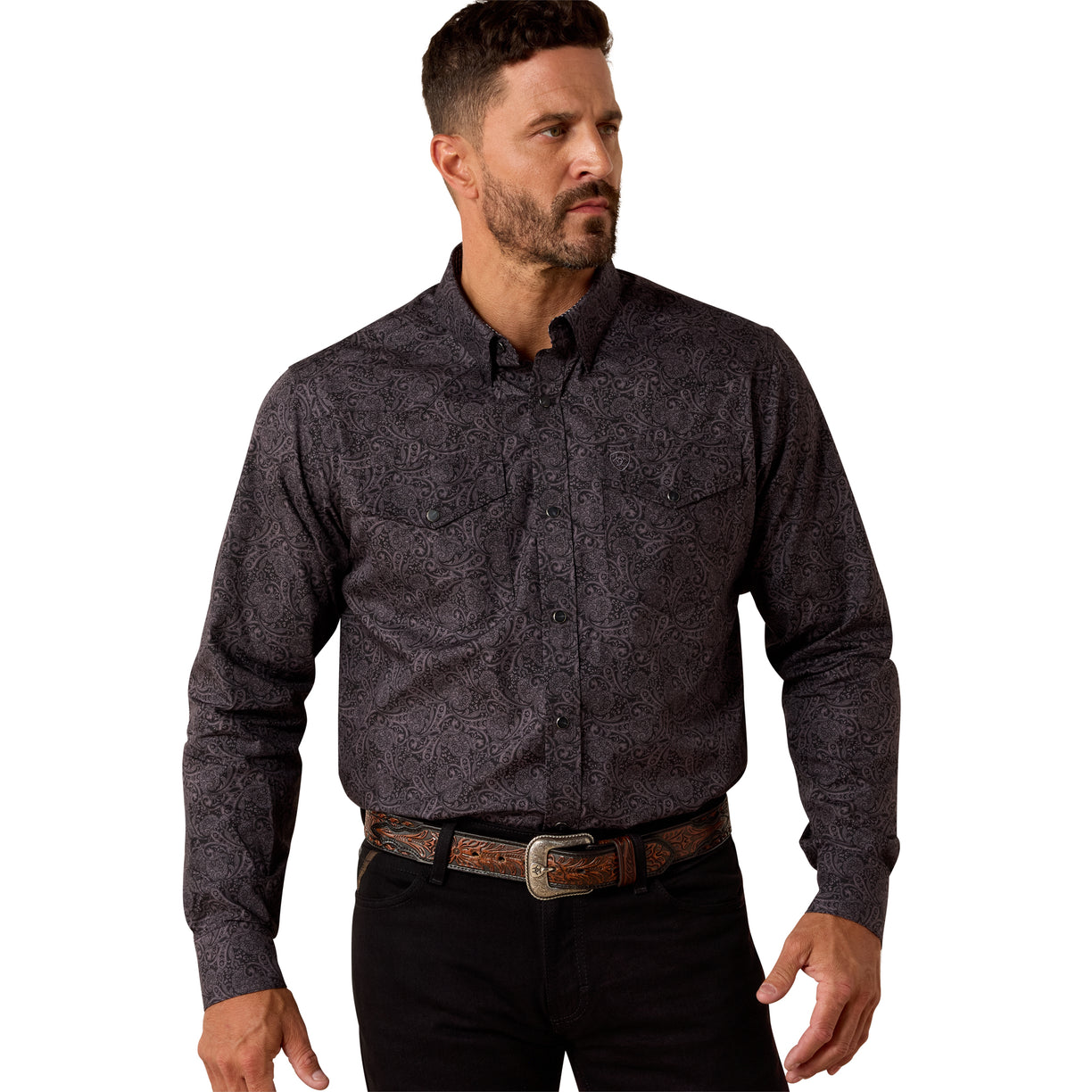 Man wearing a dark patterned shirt and black pants on a white background