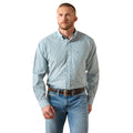A man wearing a light blue and white checkered long-sleeve button-down shirt with blue jeans and a brown belt, standing against a plain white background.