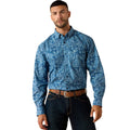 Man wearing a blue patterned shirt and dark jeans on a white background