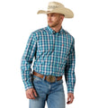 A man wearing a turquoise and blue plaid western long-sleeve button-down shirt, blue jeans, a brown leather belt with a large silver buckle, and a beige cowboy hat, photographed against a solid white background.
