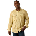 A man wearing a light beige western-style button-down shirt with two chest pockets, paired with dark blue jeans, photographed against a solid white background.