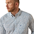A man wearing a light blue and white micro-patterned button-down shirt, shown in a close-up side profile against a plain white background.