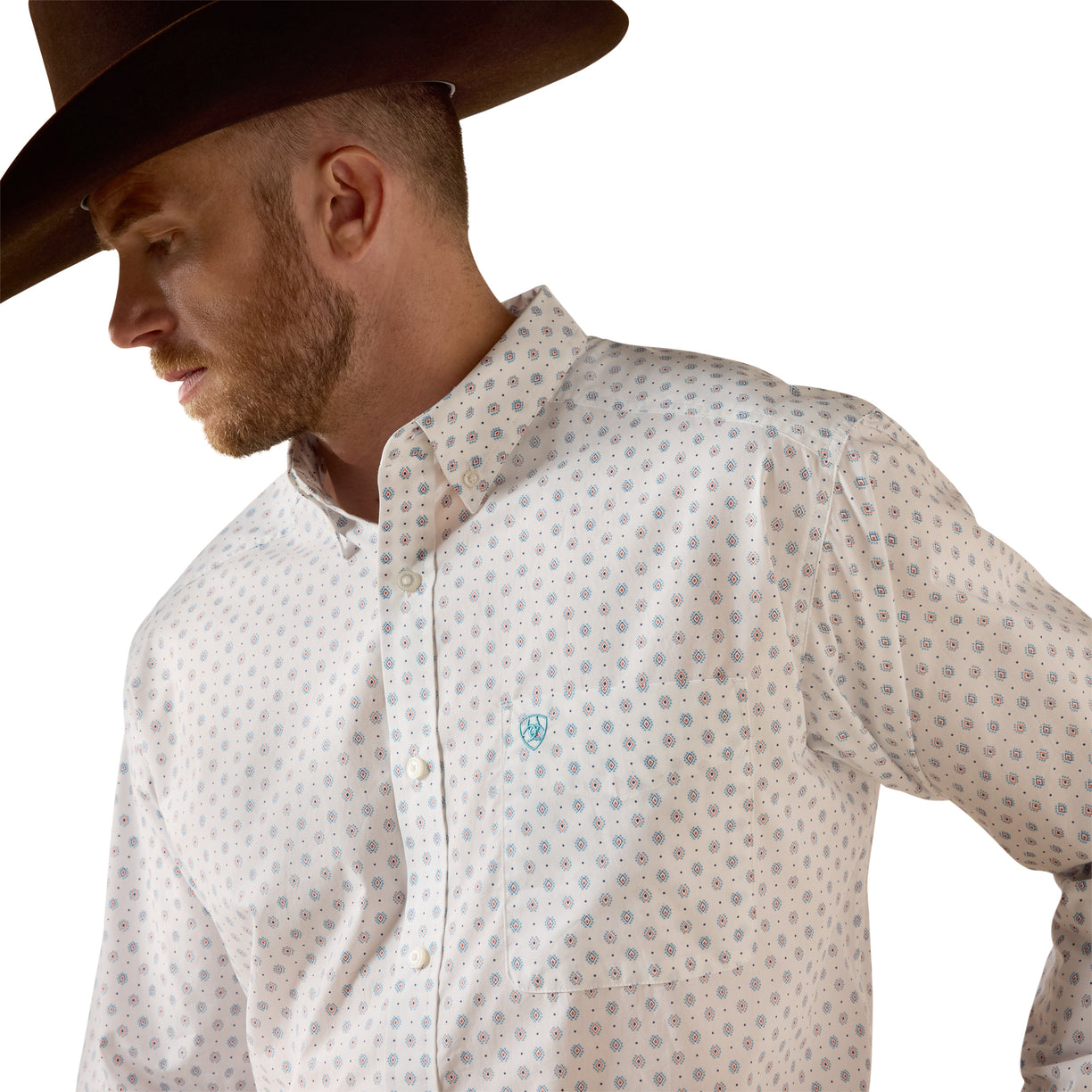 A man wearing a brown cowboy hat and a light-colored western button-down shirt with a small blue geometric pattern, shown in a close-up profile shot against a white background.