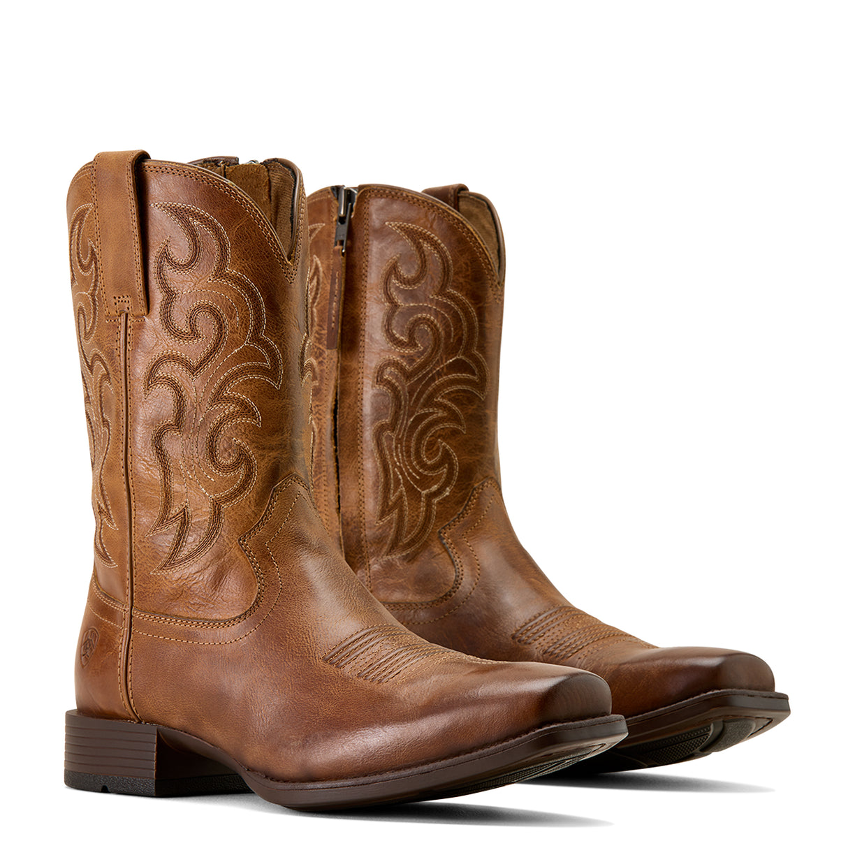 Pair of brown cowboy boots with intricate designs on a white background