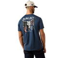 Man wearing a blue Ariat t-shirt with a graphic design on the back, standing against a beige background.